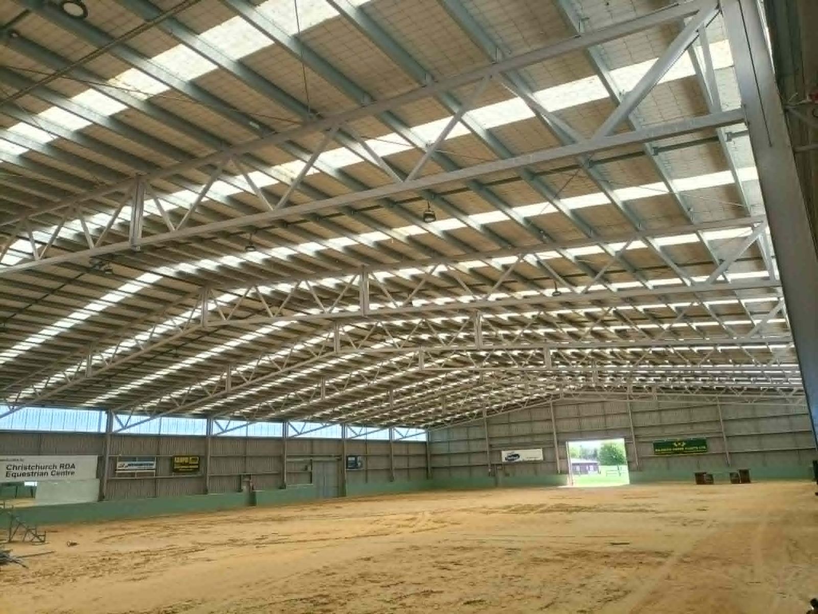 The empty indoor arena with a sand floor and high roof