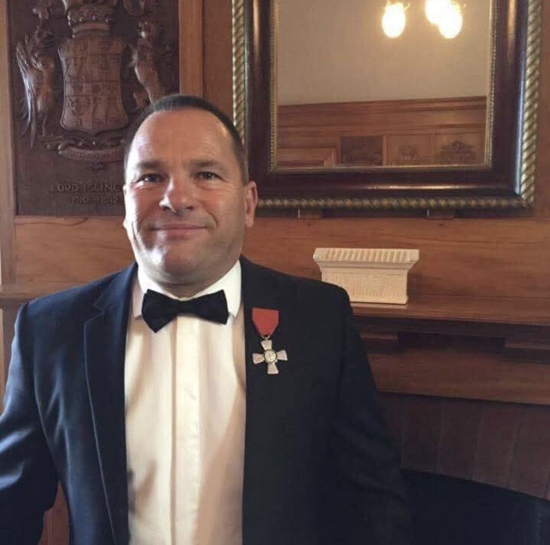 A man in a dinner suit and bow tie wearing a medal